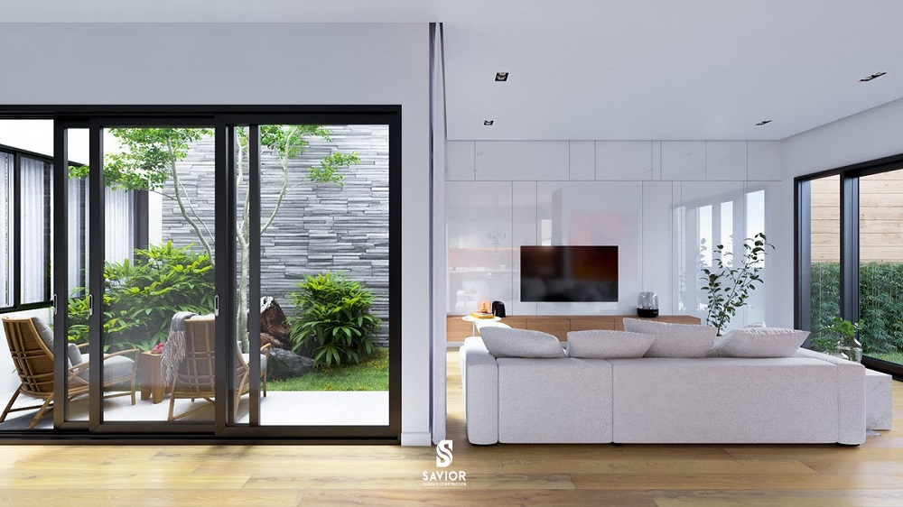 Khoảng đáy giếng trời ở tầng 1 được tận dụng trồng tiểu cảnh, sự xuất hiện của bộ bàn ghế thư giãn và tường ốp gạch giả đá, không gian xanh mướt với sự tinh tế và đẹp mắt, tạo nên sự cuốn hút mới mẻ